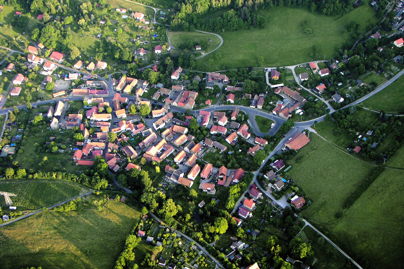 Luftaufnahme des Ortsteils. Zu sehen sind Wiesen und Häuser des Ortsteils