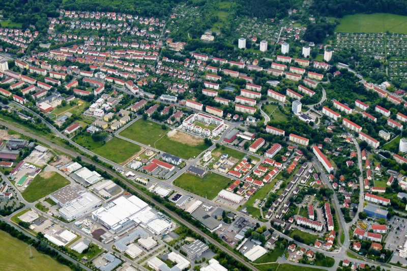Der Ortsteil Jena-Nord mit Wohnhäusern, Gewerbegebiet und Wiesen.