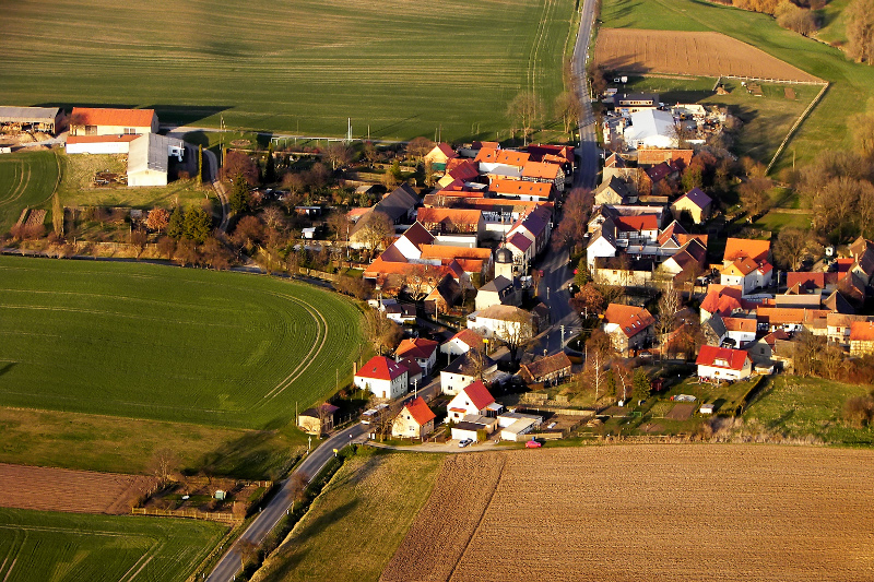 Der Ortsteil Krippendorf mit Wohnhäusern, einer Kirche, Feldern und Wiesen.