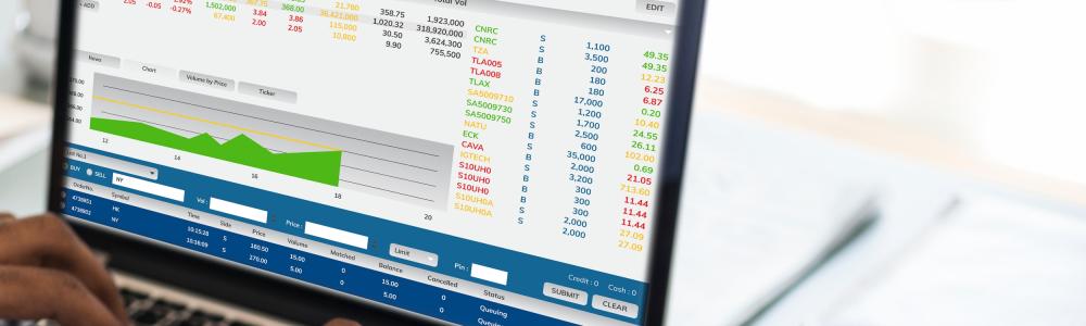 Laptop mit statistischen Grafiken auf einem Schreibtisch, ein Mann schreibt auf der Tastatur